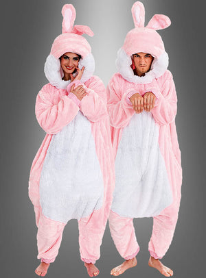 Zwei Personen, die das „Rosa Plüsch Hase für Damen oder Herren“-Kostüm tragen – aus übergroßem rosa Plüschstoff, mit Kapuzen, langen Ohren und weißen Bäuchen –, stehen barfuß vor einem grauen Hintergrund und bilden so ein perfektes Gruppenkostüm für Partys oder Veranstaltungen.