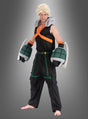 Ein Mann im Katsuki-Bakugo-Kostüm für Erwachsene aus „My Hero Academia“, ideal für Anime-Cosplay für Erwachsene, mit stacheligen blonden Haaren, einem schwarz-orangefarbenen, ärmellosen Oberteil, übergroßen grünen Handschuh-Requisiten und einer schwarzen Cargohose vor grauem Hintergrund.