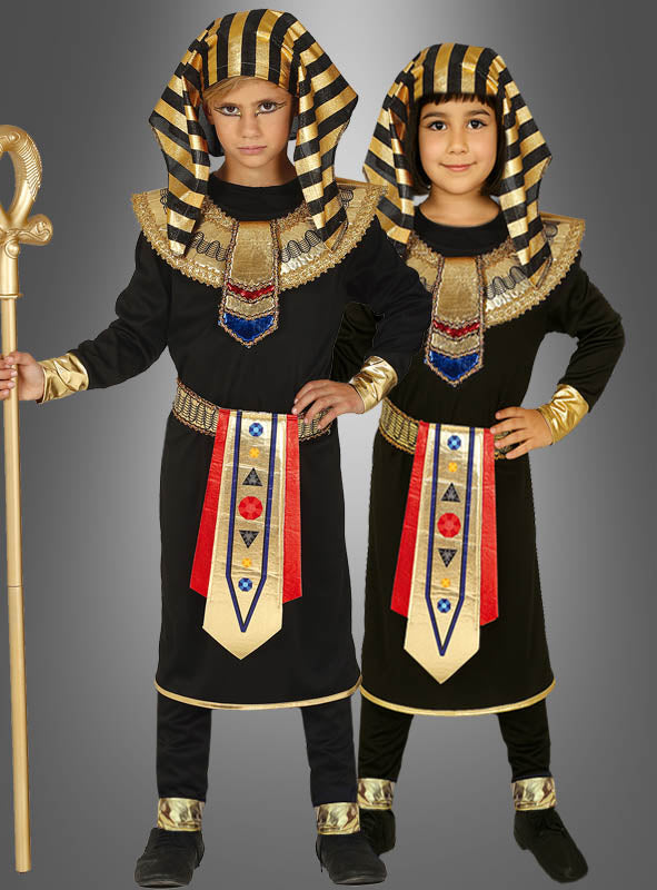 Zwei Kinder tragen passende Pharao-Kostüme für Kinder in Schwarz und Gold, jeweils mit gestreiften Kopfbedeckungen, verzierten Kragen und geschmückten Schärpen, während sie vor einem grauen Hintergrund stehen.