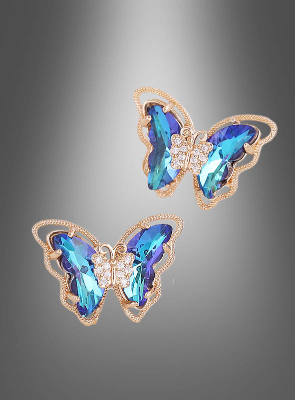 Schmetterling-Ohrstecker, schillernd, mit blauen Edelsteinflügeln und kleinen klaren Steinen am Körper, dargestellt vor einem grauen Hintergrund mit Farbverlauf.