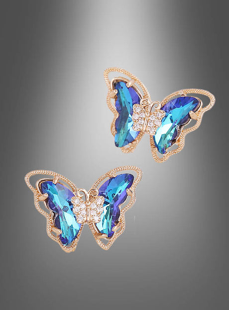 Schmetterling-Ohrstecker, schillernd, mit blauen Edelsteinflügeln und kleinen klaren Steinen am Körper, dargestellt vor einem grauen Hintergrund mit Farbverlauf.