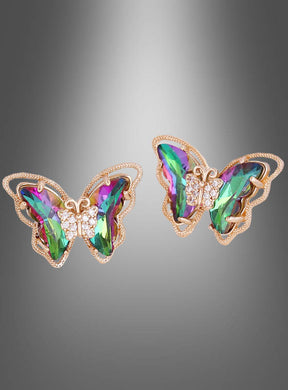 Ein Paar schillernde „Schmetterling“-Ohrstecker aus Gold, die in Form von Schmetterlingen gestaltet sind und über mehrfarbige Edelsteinflügel sowie kleine klare Steine am Körper verfügen; präsentiert vor einem grau abgestuften Hintergrund.
