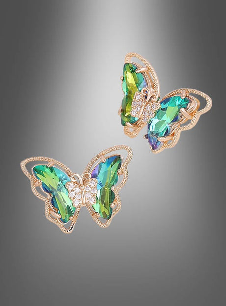 Ein Paar schillernde „Schmetterling“-Ohrstecker in Schmetterlingsform mit grünen und blauen Edelsteinen sowie goldenen Akzenten, präsentiert vor einem grauen Hintergrund mit Farbverlauf.