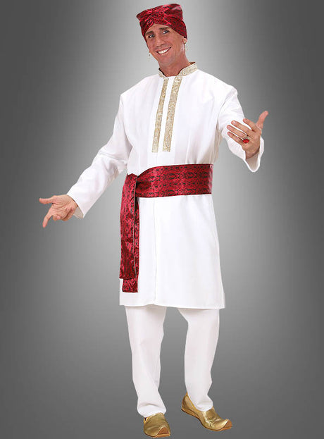 Ein Mann im „Inder-Kostüm“ eines Bollywood-Stars – ein weißes traditionelles Outfit, kombiniert mit goldenen Schuhen, einer rot gemusterten Schärpe und einem passenden Kopftuch – steht vor einem grauen Hintergrund und strahlt den raffinierten Stil indischer Kleidung aus, wie man ihn von echten Bollywood-Stars kennt.