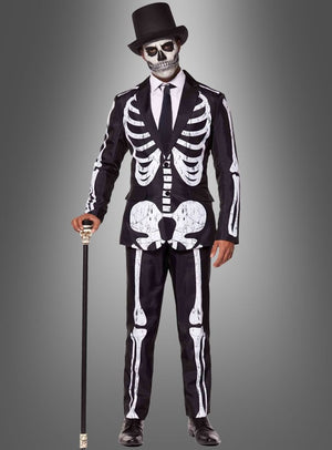 Eine Person, die den „Skelett Anzug Halloween Suitmeister“ trägt, mit passender Gesichtsbemalung und einem schwarzen Zylinder, die einen Spazierstock in der Hand hält und vor einem grauen Hintergrund mit Farbverlauf steht.