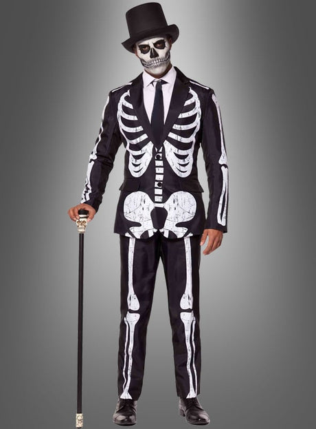Eine Person, die den „Skelett Anzug Halloween Suitmeister“ trägt, mit passender Gesichtsbemalung und einem schwarzen Zylinder, die einen Spazierstock in der Hand hält und vor einem grauen Hintergrund mit Farbverlauf steht.