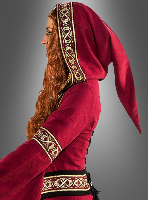 Person in Seitenansicht, die das mittelalterliche Kleid „Morgana“ mit Kapuze in Rot und goldbesticktem Saum trägt, im Stil eines Kapuzenkleides, vor einem schlichten grauen Hintergrund stehend.
