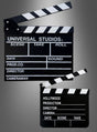 Zwei schwarz-weiße Filmklappen als Hollywood-Partyzubehör mit beschrifteten Feldern für Szene, Take, Roll, Datum, Ton, Produktion, Regisseur, Kameramann und Kameraangaben heben sich von einem grau verlaufenden Hintergrund ab – das perfekte Accessoire für jede Hollywood-Party.