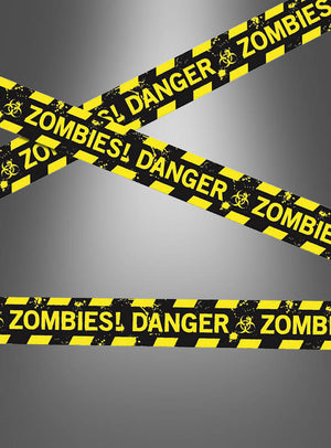 Gelb-schwarzes Absperrband mit der Aufschrift „DANGER! ZOMBIES!“ und Biogefährdungssymbolen vor einem grauen Farbverlaufshintergrund – ideal als 6 Meter langes Halloween-Absperrband für Ihre nächste Zombie-Party oder als gruselige Dekoration.