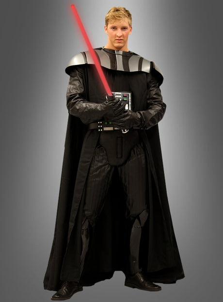 Eine Person im „Star Wars“-Darth-Vader-Kostüm der Supreme Edition, bestehend aus einem schwarzen Sci-Fi-Umhang und einer Rüstung, steht mit einem roten Lichtschwert in der Hand vor einem schlichten grauen Hintergrund und verkörpert damit perfekt den ikonischen Look von Darth Vader aus „Star Wars“. Eine ideale Wahl für alle, die auf der Suche nach einem beeindruckenden „Star Wars“-Kostüm der Supreme Edition sind.