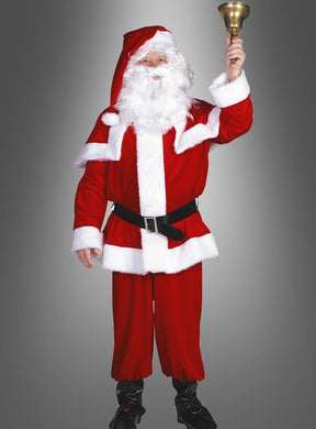 Eine Person, die das „Hochwertiges Weihnachtsmannkostüm 4-teilig“ trägt, hält in ihrer rechten Hand eine Glocke hoch und steht vor einem schlichten grauen Hintergrund.