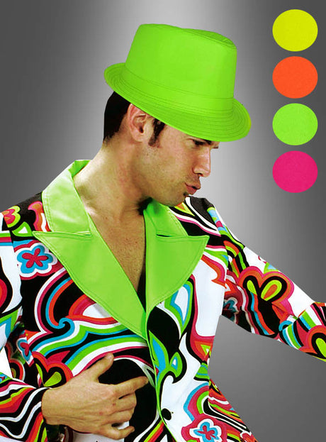 Ein Mann, der einen Schriller Party Hut 80er in Neonfarben in Neongrün und einen bunten Anzug mit Retro-Muster trägt, steht vor einem Hintergrund mit Farbverlauf, auf dem rechts vier neongefärbte Kreise zu sehen sind – perfekt für eine 80er-Jahre-Party.