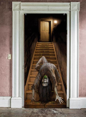 Ein schwach beleuchteter Türdurchgang gibt den Blick auf eine Treppe frei, auf der eine verzerrte, gespenstische Gestalt mit weit aufgerissenem Mund und großen Augen hinunterkriecht – eine beunruhigende Atmosphäre, ideal für dein Halloween-Türposter „Nonne oder Treppe“ (179 x 80 cm) und der letzte Schliff für deine ultimative Halloween-Dekoration.