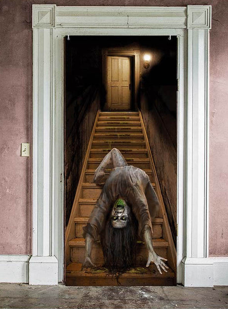 Ein schwach beleuchteter Türdurchgang gibt den Blick auf eine Treppe frei, auf der eine verzerrte, gespenstische Gestalt mit weit aufgerissenem Mund und großen Augen hinunterkriecht – eine beunruhigende Atmosphäre, ideal für dein Halloween-Türposter „Nonne oder Treppe“ (179 x 80 cm) und der letzte Schliff für deine ultimative Halloween-Dekoration.