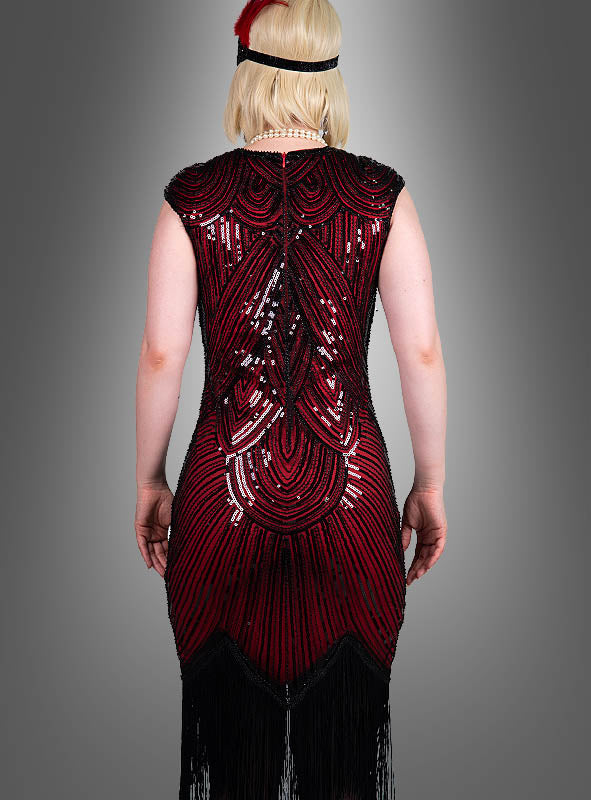 Eine Person steht mit dem Rücken zur Kamera und trägt das „Hochwertiges Gatsby Kleid Daisy“ – ein rot-schwarzes Flapper-Kleid mit Pailletten, das von Kleidern der 20er Jahre inspiriert ist – mit schwarzen Fransen am Saum, dazu eine Perlenkette und ein schwarzes Stirnband, das mit einer roten Feder verziert ist; das Ganze vor einem grauen Hintergrund.