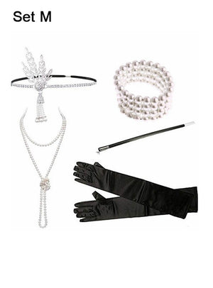 Eine Perlenkette, ein Stirnband, ein Perlenarmband, schwarze Handschuhe und eine schwarze Zigarettenspitze sind elegant auf einem weißen Hintergrund präsentiert, der mit „20er Jahre Zubehör Set 5-teilig silber“ beschriftet ist – perfekt, um jedes Charleston-Outfit abzurunden.