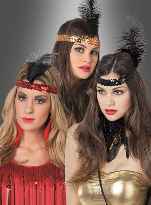 Drei Frauen mit Pailletten-Stirnbändern, an denen jeweils eine große schwarze Feder prangt, posieren vor einem grauen Hintergrund mit Farbverlauf in klassischen Kostümen im Flapper-Stil. Jeder dieser Haarschmuck aus den 20er Jahren mit schwarzer Feder verleiht ihrem schwungvollen Outfit authentisches Flair der 1920er Jahre und macht sie zum perfekten Beispiel für den zeitlosen Flapper-Accessoire-Stil.
