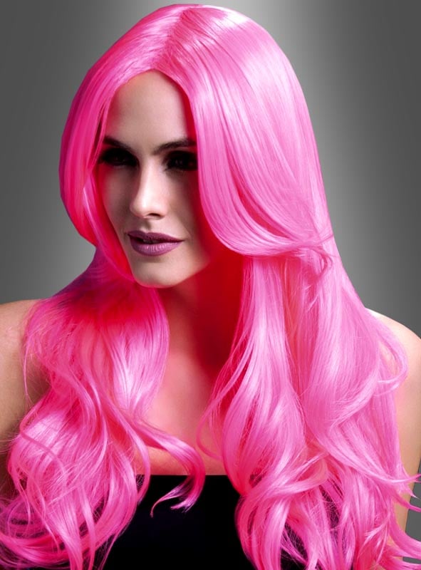 Eine Person mit langen, welligen, leuchtend pinkfarbenen Haaren – Khloe Langhaarperücke in Pink oder Rot – posiert vor einem grauen Hintergrund mit Farbverlauf und trägt ein schwarzes Oberteil – perfekt für jede 80er-Party.