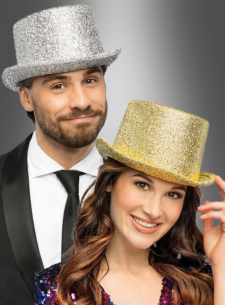 Ein Mann und eine Frau stehen lächelnd vor einem grauen Hintergrund mit Farbverlauf; beide tragen den „Glitzer-Zylinder“ in Silber oder Gold und präsentieren so ihr festliches Karnevalskostüm mit funkelndem Flair.
