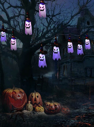 Eine Halloween-Szene mit der 280 cm langen Halloween-Girlande, an der leuchtende LED-Kürbisse oder Geister an den Ästen hängen, umgeben von geschnitzten Kürbissen auf dem Boden und einem schattenhaften, gruseligen Haus im Hintergrund – die perfekte Halloween-Dekoration, um eine gespenstische Atmosphäre zu schaffen.