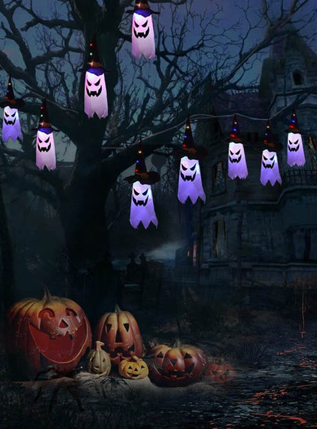 Eine Halloween-Szene mit der 280 cm langen Halloween-Girlande, an der leuchtende LED-Kürbisse oder Geister an den Ästen hängen, umgeben von geschnitzten Kürbissen auf dem Boden und einem schattenhaften, gruseligen Haus im Hintergrund – die perfekte Halloween-Dekoration, um eine gespenstische Atmosphäre zu schaffen.