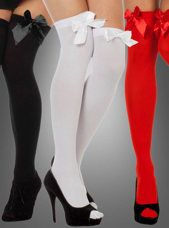 Drei Paar Overknee-Strümpfe – „Sexy Overknees mit Schleife“ in Schwarz, Weiß und Rot –, jeweils mit einer großen Satinschleife verziert und zusammen mit High Heels vor grauem Hintergrund in Szene gesetzt. Das ideale Accessoire für ein Karnevalskostüm.
