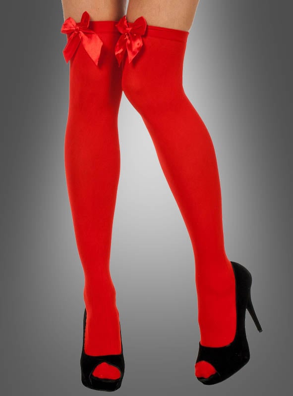 Eine Person, die rote, sexy Overknee-Stiefel mit Schleife und schwarze Peep-Toe-Schuhe mit hohen Absätzen trägt und vor einem grauen Hintergrund mit Farbverlauf steht.