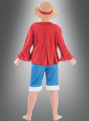 Ein Kind, das ein „Ruffy“-Kostüm von „Kinder One Piece“ trägt – bestehend aus einem Strohhut, einem roten Langarmhemd und blauen Shorts –, steht barfuß vor einem Hintergrund mit Farbverlauf und ist mit dem Rücken zur Kamera gewandt.