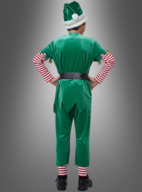 Eine Person steht mit den Händen in den Hüften da und trägt das „Grüner Weihnachtself“-Kinderkostüm mit rot-weiß gestreiften Ärmeln und Socken, einem schwarzen Gürtel und einer passenden Mütze; die Abbildung zeigt die Person von hinten vor einem grauen Hintergrund – ideal als Elfenkostüm für Jungen und Mädchen zu festlichen Anlässen.