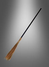 Der „Hexenbesen für Zauberer und Hexen“ mit langem schwarzem Stiel und Naturborsten wird vor einem schlichten grauen Hintergrund mit Farbverlauf präsentiert – ideal als Halloween-Accessoire oder zur Vervollständigung Ihres Hexenkostüms.