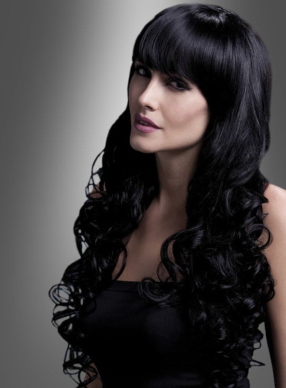 Eine Frau mit langen, welligen schwarzen Haaren und geradem Pony, die ein ärmelloses schwarzes Oberteil trägt, posiert vor einem grau verlaufenden Hintergrund. Ihr Look bringt die Eleganz der „Isabelle Deluxe Lockenperücke Langhaar“ zur Geltung und verbindet natürliche Schönheit mit vielseitigem Stil.