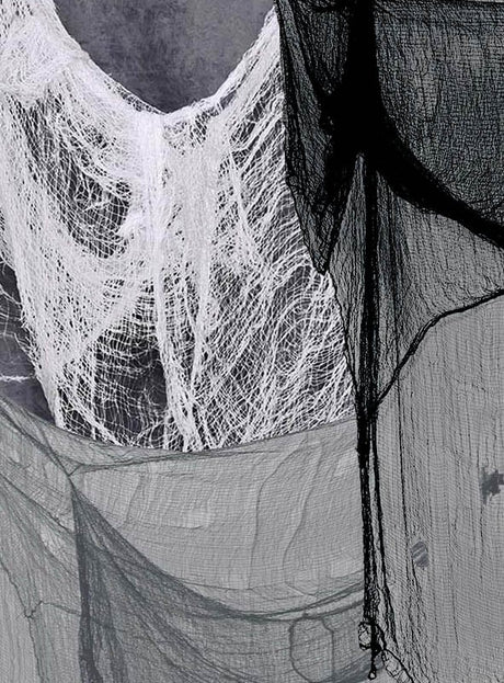 Nahaufnahme von geschichteten, halbtransparenten schwarzen und weißen Gaze-Stoffen – wie beispielsweise dem „Riesiges Dekotuch 2x5 Meter“ – die in überlappenden Mustern vor einem neutralen Hintergrund drapiert sind.