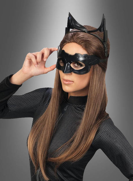 Eine Person, die das Catwoman-Set trägt – bestehend aus einem schwarzen Catsuit, einer schwarzen Maske und einem Stirnband mit Katzenohren –, posiert vor einem grauen Hintergrund mit Farbverlauf.