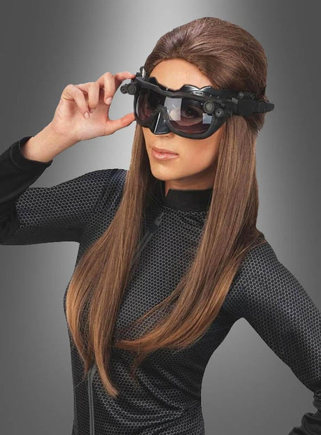 Eine Person, die das Catwoman-Set trägt – bestehend aus einem strukturierten schwarzen Outfit und einer großen, futuristischen schwarzen Schutzbrille –, steht vor einem grauen Hintergrund mit Farbverlauf.