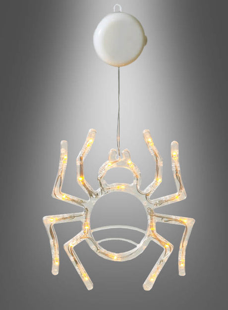 Eine leuchtende Spinne (36 cm) mit LED hängt an einem Draht, der an einem runden weißen Sockel befestigt ist, vor einem grauen Hintergrund mit Farbverlauf.