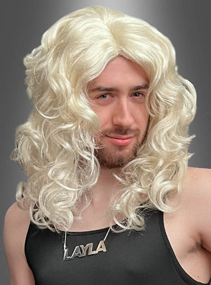 Eine Person, die die „Layla-Perücke, blond mit Locken“ trägt, kombiniert mit einem schwarzen Oberteil und einer Halskette mit der Aufschrift „LAYLA“, vor einem grauen Hintergrund.