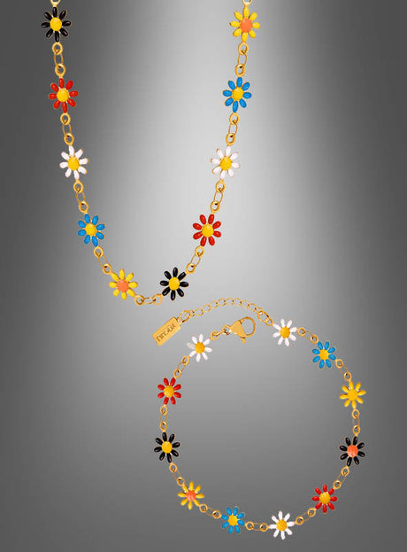 Verleihen Sie jedem Outfit einen verspielten Farbtupfer mit dem „Buntes Blumenschmuck Set“ aus Armband und Kette: eine goldene Halskette und ein Armband, verziert mit Anhängern in Gänseblümchenform in leuchtenden Rot-, Gelb-, Blau-, Schwarz- und Weißtönen. Vor einem grau verlaufenden Hintergrund präsentiert, verleiht dieses bezaubernde Set Ihrem Look fröhliches Boho-Flair und fängt die temperamentvolle Essenz klassischen Hippie-Schmucks ein.