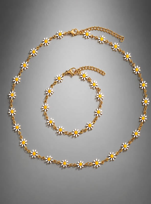 Schmuckset „Weiße Blumen“ – Kette & Armband mit zarten weißen und gelben Gänseblümchen-Anhängern, die sich wunderschön vor einem grauen Hintergrund abheben. Dieses bezaubernde Set ist perfekt, um jedem Outfit einen Hauch von Boho-Schmuck-Stil zu verleihen.