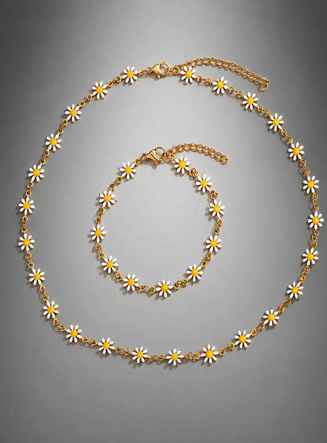 Schmuckset „Weiße Blumen“ – Kette & Armband mit zarten weißen und gelben Gänseblümchen-Anhängern, die sich wunderschön vor einem grauen Hintergrund abheben. Dieses bezaubernde Set ist perfekt, um jedem Outfit einen Hauch von Boho-Schmuck-Stil zu verleihen.