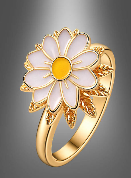 Der „Blumenring mit drehbarer Blüte“ ist kunstvoll als eleganter Goldring in Form eines Gänseblümchens gestaltet, der weiße Blütenblätter, eine gelbe Mitte und goldene Blätter aufweist – präsentiert vor einem sanft verlaufenden grauen Hintergrund.