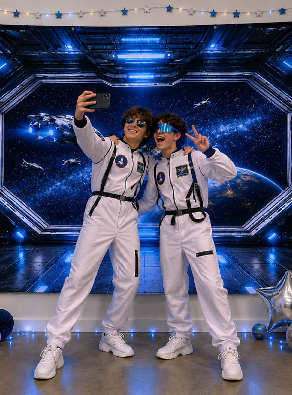 Zwei Personen in weißen Astronautenanzügen machen ein Selfie und posieren mit Peace-Zeichen vor einer „Weltall“-Fotowand (170 x 200 cm), die mit Lichtern und Sternen verziert ist und die perfekte Kulisse für jede Science-Fiction-Szene bildet.