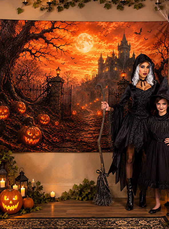 Zwei Personen in Hexenkostümen stehen vor dem Halloween-Hintergrund „Schloss mit Kürbissen“ (170 x 200 cm), auf dem ein gruseliges Schloss, Vollmond, Kürbisse, Kerzen und Herbstblätter zu sehen sind. Diese bezaubernde Kulisse bildet den perfekten Rahmen für unvergessliche Fotos vor der ultimativen Halloween-Fotowand.