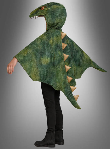 Ein Kind trägt das „Waschbarer T-Rex Umhang Dinokostüm Kids“ in Grün, das eine Kapuze, Stacheln am Rücken und einen Schwanz hat. Das Kostüm ist hier von der Seite vor einem grauen Hintergrund zu sehen – ideal als Verkleidung für die Kinderfasching und mit Sicherheit ein T-Rex-Dinokostüm, das Kinder lieben werden.
