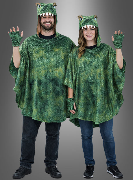 Zwei Personen, die identische grüne Dino-T-Rex-Ponchos für Erwachsene tragen – komplett mit Kapuze, Handschuhen und strukturierten Schuppen –, stehen nebeneinander und winken vor einem grauen Hintergrund mit Farbverlauf. Ihre verspielten Poncho-Designs verleihen dem klassischen T-Rex-Kostüm-Look eine lustige Note.