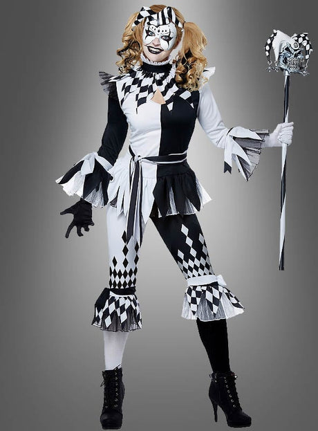 Eine Person, die das „Harlekin Clown für Damen“-Kostüm trägt – mit Rüschenärmeln, einer passenden Maske und einem Narrenstab –, steht vor einem schlichten grauen Hintergrund.