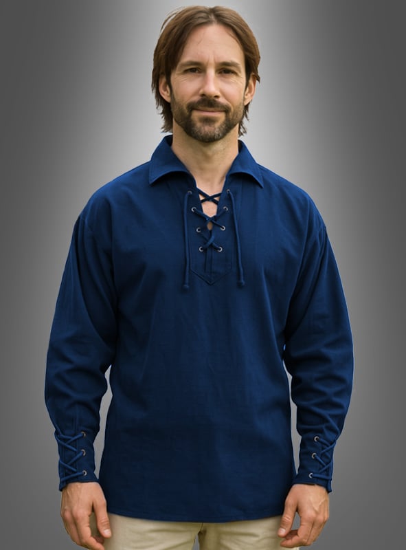 Ein Mann mit mittellangem braunem Haar und Bart trägt das blaue „Mittelalterhemd Heinrich für Herren“ mit Schnürung vorne und an den Ärmeln und steht vor einem grauen Hintergrund mit Farbverlauf.