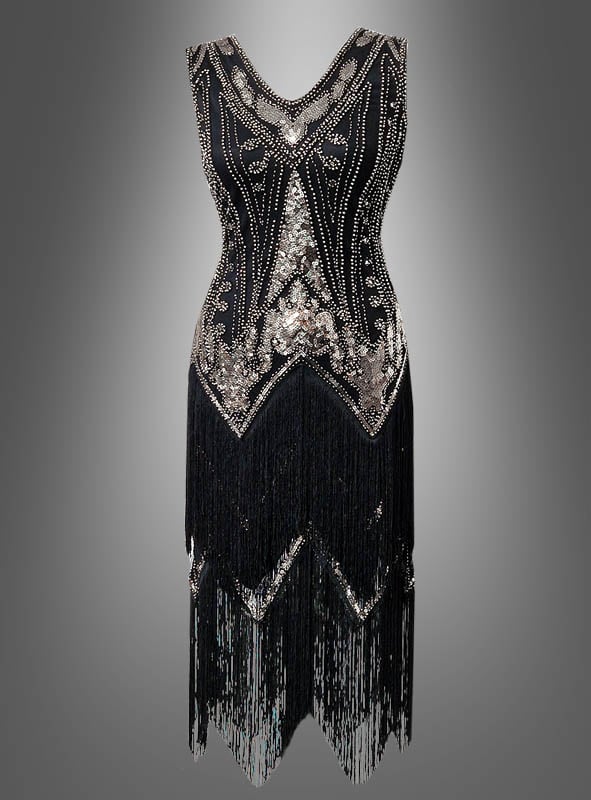 Das Deluxe-Flapperkleid „2-reihige Fransen Iris“ ist ein schwarzes, ärmelloses Kleid im Stil der 20er Jahre, verziert mit silbernen Perlen und Pailletten, mit V-Ausschnitt und doppellagigen Fransen am Saum– dieses elegante Flapperkleid mit Pailletten kommt vor einem grauen Hintergrund mit Farbverlauf perfekt zur Geltung.