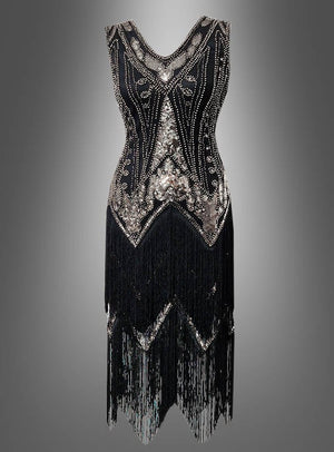 Das Deluxe-Flapperkleid „2-reihige Fransen Iris“ ist ein schwarzes, ärmelloses Kleid im Stil der 20er Jahre, verziert mit silbernen Perlen und Pailletten, mit V-Ausschnitt und doppellagigen Fransen am Saum– dieses elegante Flapperkleid mit Pailletten kommt vor einem grauen Hintergrund mit Farbverlauf perfekt zur Geltung.