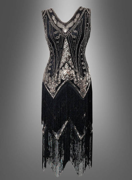 Das Deluxe-Flapperkleid „2-reihige Fransen Iris“ ist ein schwarzes, ärmelloses Kleid im Stil der 20er Jahre, verziert mit silbernen Perlen und Pailletten, mit V-Ausschnitt und doppellagigen Fransen am Saum– dieses elegante Flapperkleid mit Pailletten kommt vor einem grauen Hintergrund mit Farbverlauf perfekt zur Geltung.
