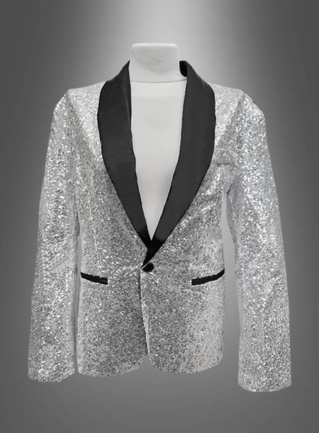 Ein silberner Paillettenblazer mit schwarzem Satinrevers und schwarz eingefassten Taschen, präsentiert auf einem weißen Mannequin-Torso vor einem grauen Hintergrund mit Farbverlauf: Diese „Deluxe Pailletten Jacke“ verkörpert mit ihrem schillernden Pailletten-Finish und den raffinierten Details den Geist einer zeitgenössischen Smokingjacke.